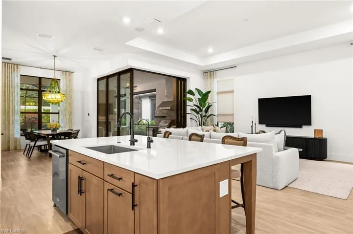 Kitchen featuring hanging light fixtures, brown cabinetry, light wood-style floors, a breakfast bar, and recessed lighting