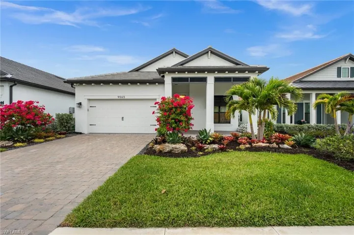 View of front of home with decorative driveway, a front lawn, an attached garage, and stucco siding