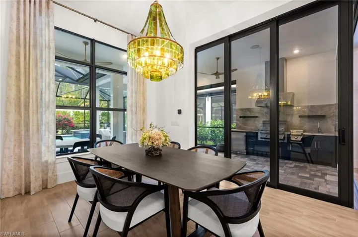 Dining room with a chandelier, wood finished floors, and a sunroom
