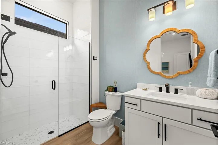 Bathroom with a shower stall, vanity, and light wood finished floors