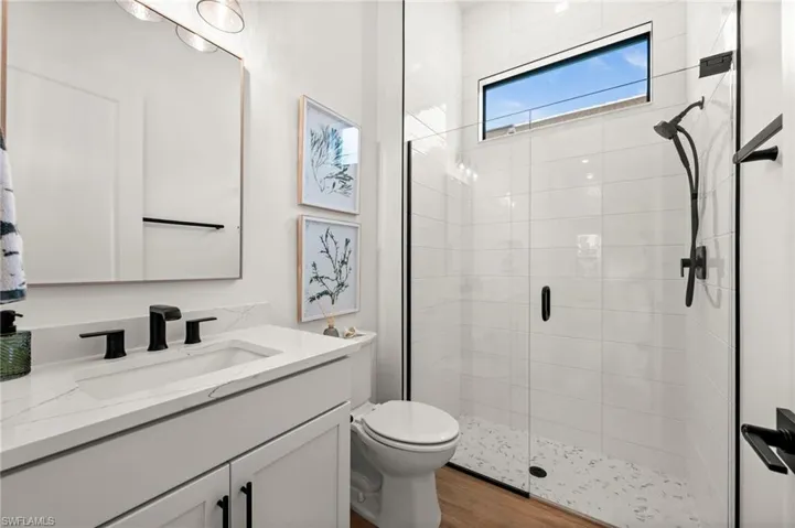 Bathroom featuring a shower stall, vanity, and light wood-type flooring