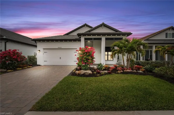 View of front of home featuring decorative driveway, a front lawn, a garage, and stucco siding