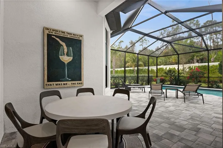 View of patio / terrace featuring a lanai, a sunroom, an outdoor pool, and outdoor dining area