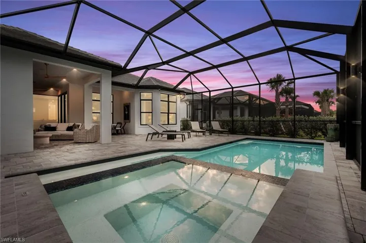 Swimming pool featuring a sunroom, a patio area, a lanai, an in-ground hot tub, and outdoor lounge area