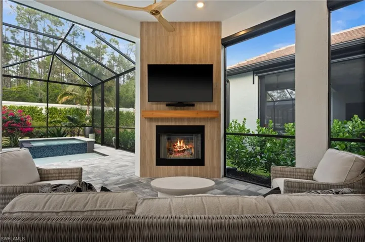 Living area featuring a sunroom, a fireplace, and ceiling fan