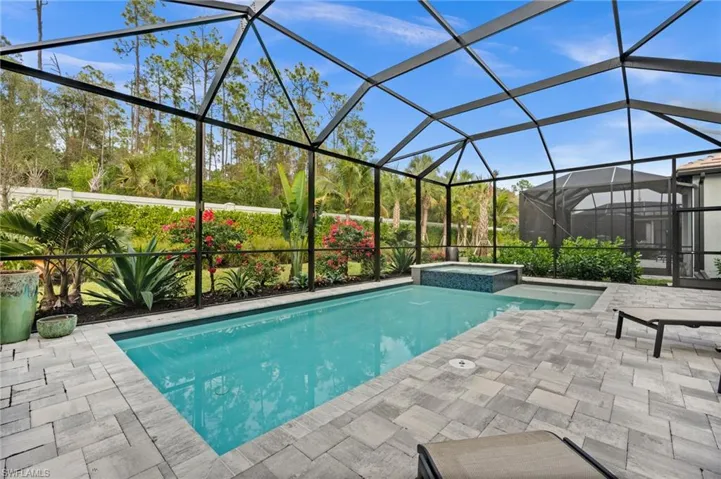 View of pool with a sunroom, a lanai, a pool with connected hot tub, and a patio