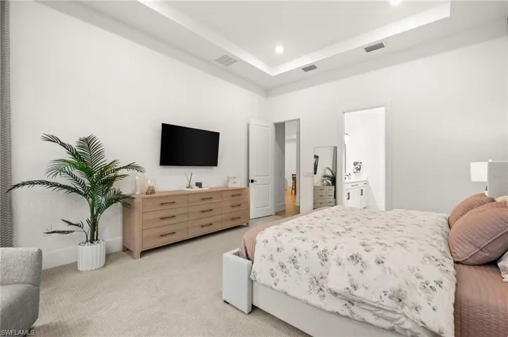 Bedroom featuring carpet, a tray ceiling, and recessed lighting