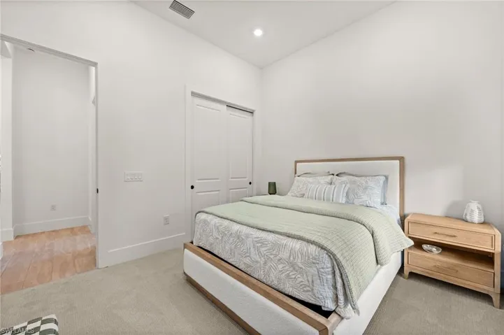 Bedroom featuring a closet, recessed lighting, and light carpet