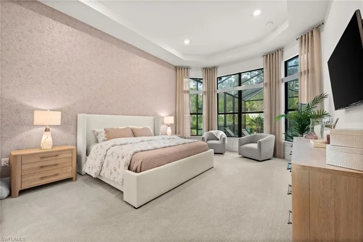 Carpeted bedroom featuring a tray ceiling and recessed lighting