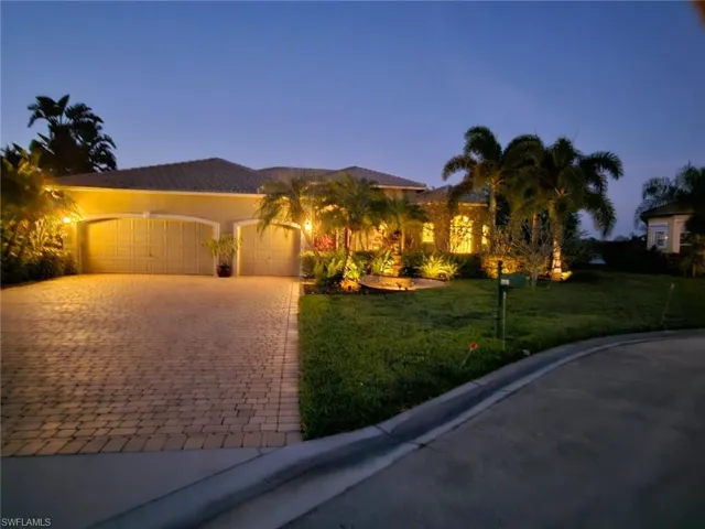 View of front of house featuring a garage, a front lawn, decorative driveway, and stucco siding