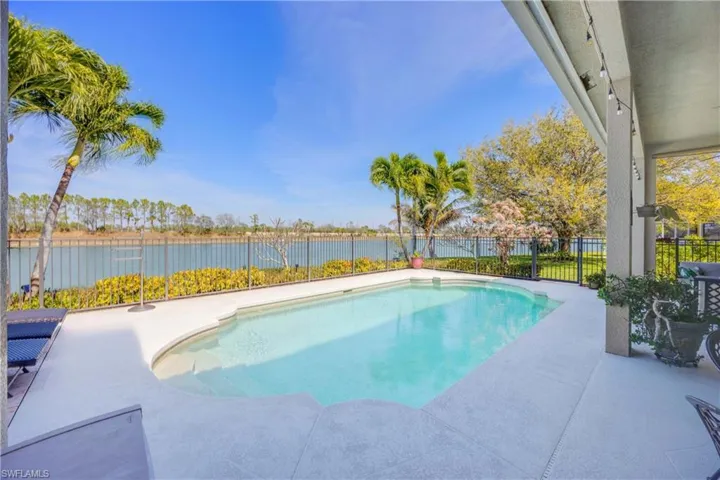 View of pool featuring a patio, a water view, a fenced backyard, and a fenced in pool