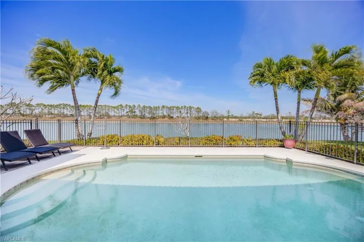 View of swimming pool featuring a fenced in pool, a water view, and fence