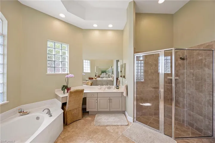 Full bath with recessed lighting, a garden tub, a shower stall, and vanity