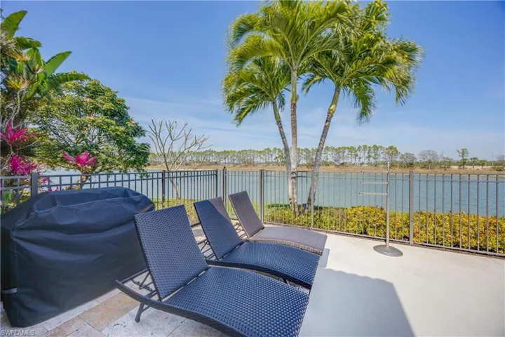 View of patio / terrace with a water view, a grill, and fence