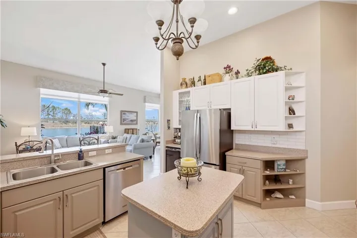 Kitchen featuring a sink, stainless steel appliances, a kitchen island, and light countertops