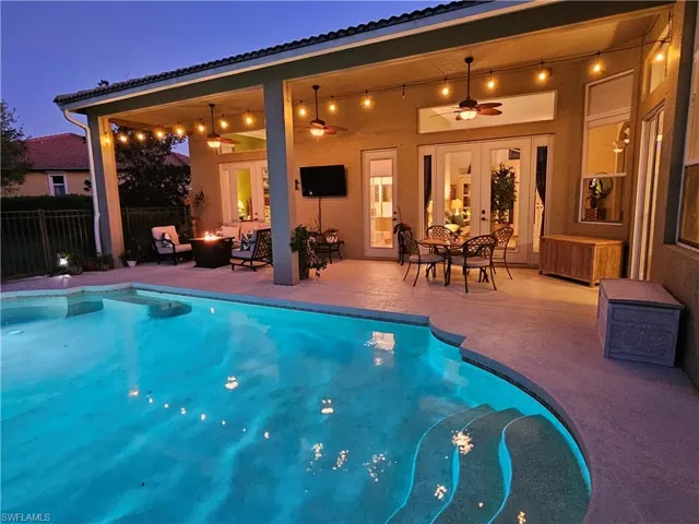 View of swimming pool with a fenced in pool, a patio area, ceiling fan, fence, and a fire pit