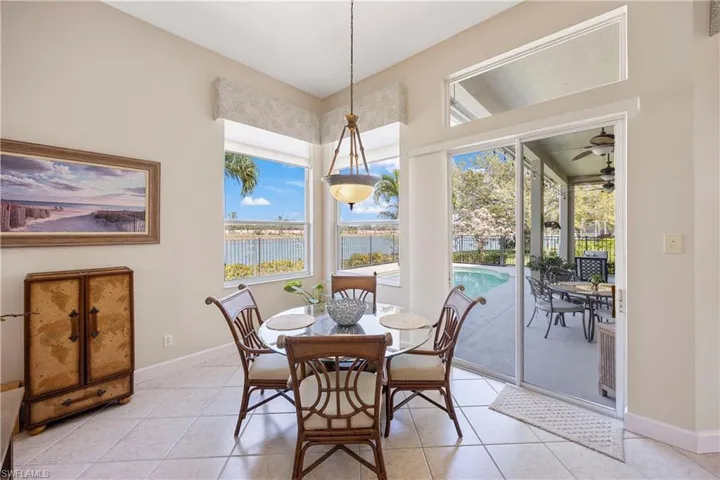 Dining space featuring a water view, baseboards, and light tile patterned floors