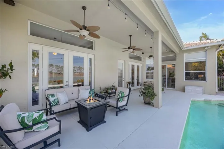 View of patio / terrace featuring ceiling fan, french doors, an outdoor living space with a fire pit, and an outdoor pool