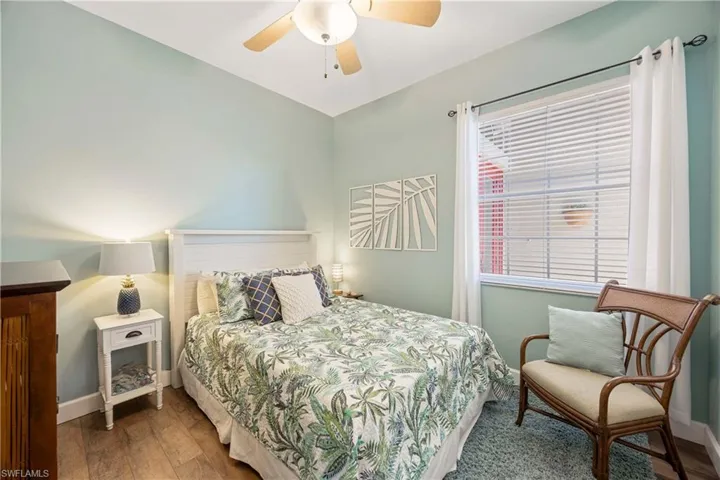 Bedroom with a ceiling fan, baseboards, and wood finished floors
