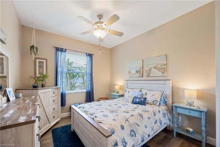 Bedroom with dark wood-style floors, baseboards, and a ceiling fan