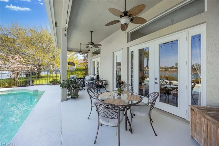 View of patio / terrace with a ceiling fan, a fenced in pool, fence, outdoor dining area, and french doors