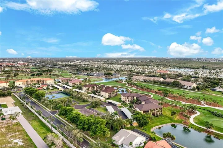 Aerial view of residential area featuring a nearby body of water and a golf course