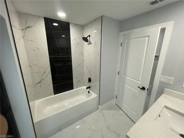 Full bath featuring shower / tub combination, marble finish flooring, recessed lighting, and vanity
