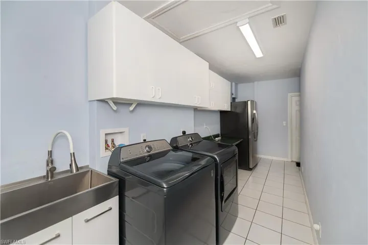 Huge Laundry Room with plenty of cabinets and laundry tub