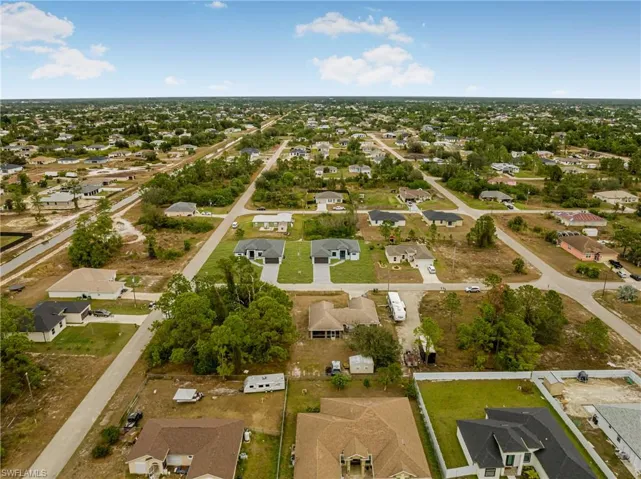 Aerial view of property and surrounding area with nearby suburban area