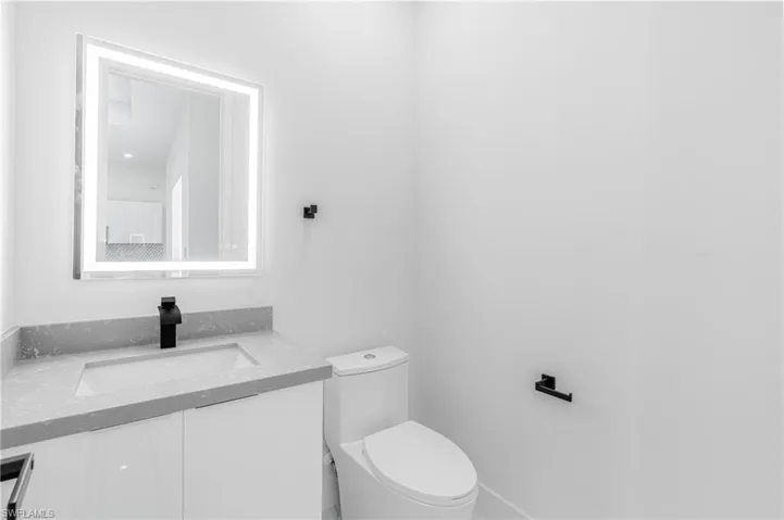 Half bathroom with vanity and toilet
