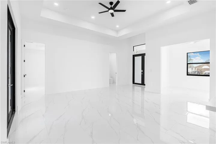Spare room with a ceiling fan, recessed lighting, and a high tray ceiling