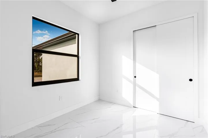Unfurnished bedroom with a closet and marble finish floors