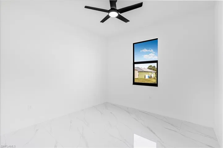 Spare room featuring a ceiling fan and marble finish floors