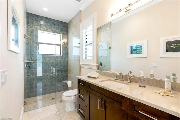 Full bathroom with a shower stall, toilet, and vanity