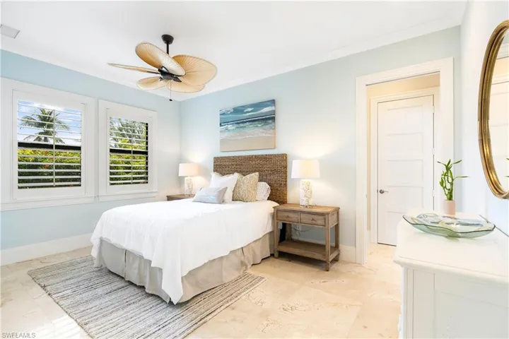 Bedroom featuring crown molding, a ceiling fan, and baseboards