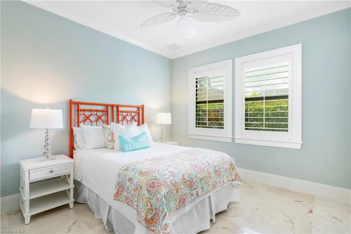 Bedroom featuring baseboards, visible vents, crown molding, and marble finish floor