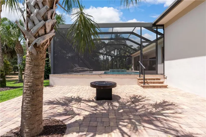 View of patio featuring glass enclosure and an outdoor pool
