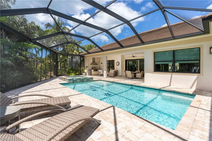 View of swimming pool featuring a patio area, outdoor lounge area, a lanai, a ceiling fan, and a pool with connected hot tub