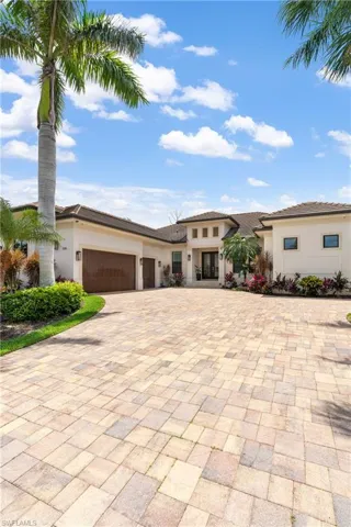 Prairie-style home featuring decorative driveway, an attached garage, and stucco siding