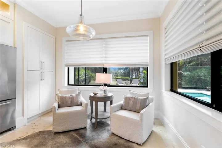 Living area with crown molding, marble finish floor, and baseboards