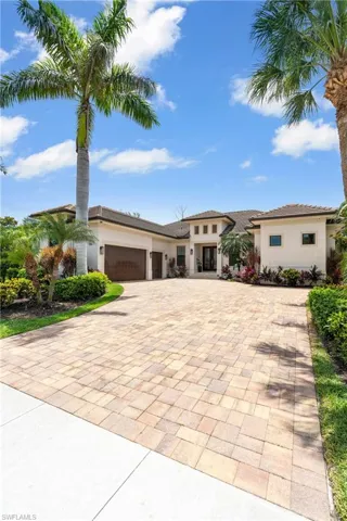 Prairie-style home featuring decorative driveway, stucco siding, and a garage
