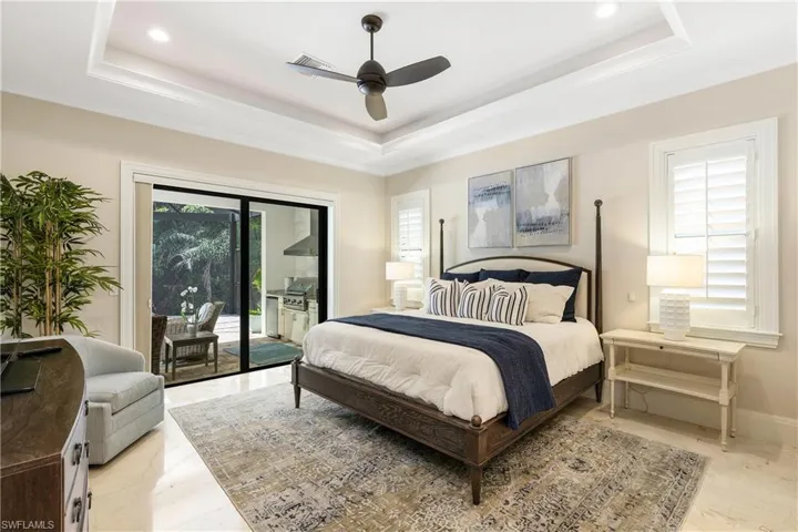 Bedroom featuring recessed lighting, access to outside, a raised ceiling, visible vents, and baseboards