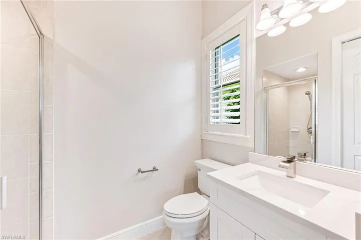 Full bathroom with a tile shower, vanity, and tile patterned flooring