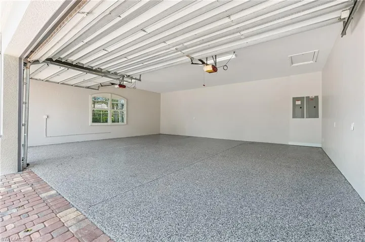 Garage featuring a garage door opener and electric panel