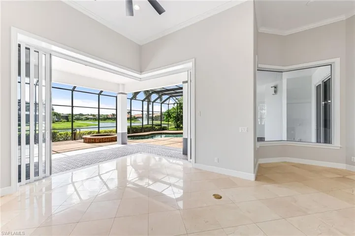 Unfurnished room with a ceiling fan, plenty of natural light, crown molding, and light tile patterned flooring