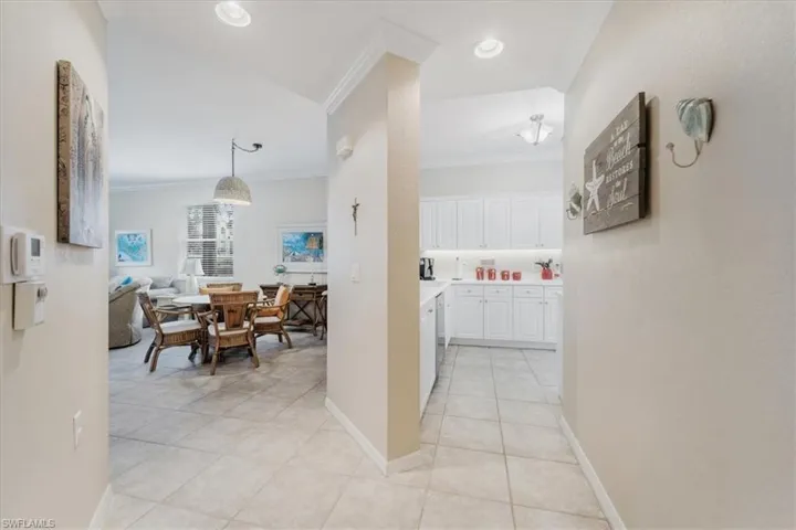 Hall with crown molding and light tile patterned floors
