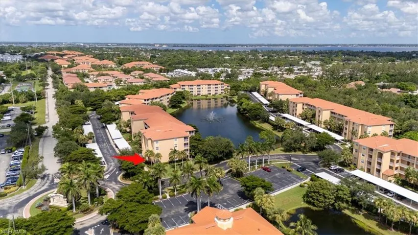 Drone / aerial view of a nearby body of water and apartment complex / building