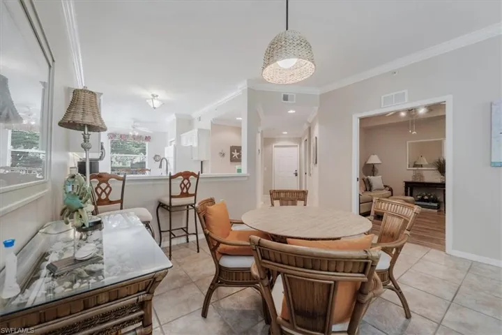 Dining room featuring light tile patterned flooring and crown molding