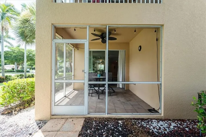 Entrance to property featuring stucco siding and a ceiling fan