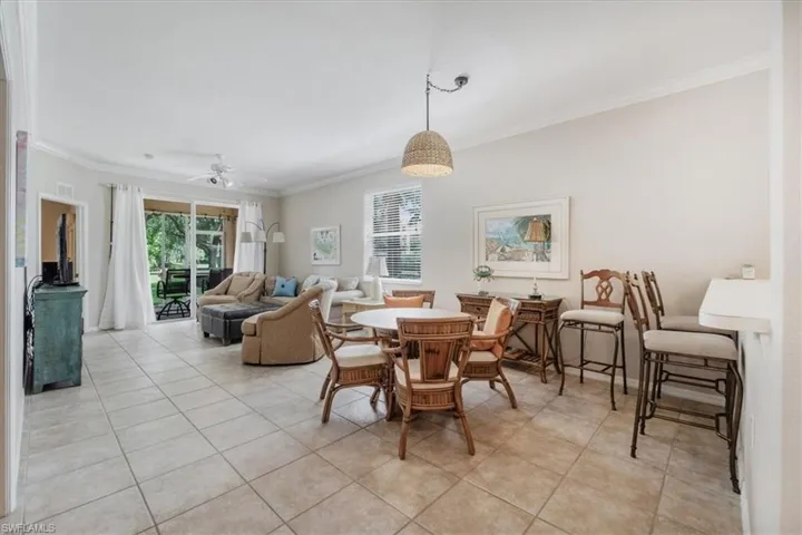 Dining room with a ceiling fan, crown molding, plenty of natural light, and light tile patterned floors